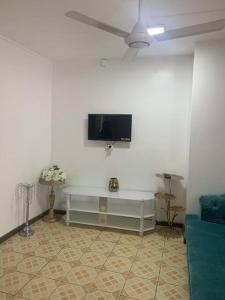 sala de estar con TV en una pared blanca en Modern with class near Airport, en Nadi