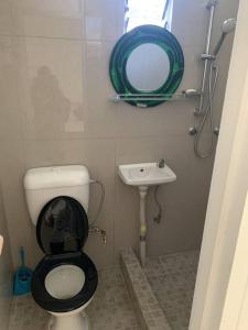 a small bathroom with a toilet and a sink at Modern with class near Airport in Nadi