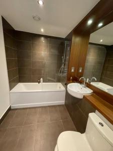a bathroom with a tub and a toilet and a sink at Peaceful 1BD Flat with Balcony - Bethnal Green in London