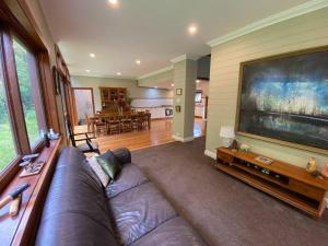 a living room with a couch and a large television at The Barn, Bowral in Bowral