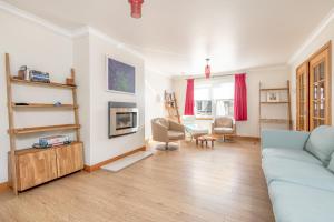 ein Wohnzimmer mit einem blauen Sofa und einem Tisch in der Unterkunft Dempster Lodge nr Old Course, Sleeps 10, Parking in St Andrews