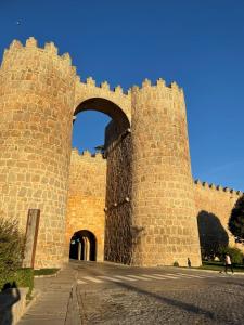 a large brick building with an arch in it at Hotel Arco San Vicente in Ávila