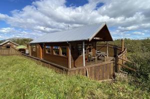 Cabaña de madera grande en un campo de hierba en Vörðufell Country Cabin, en Selfoss