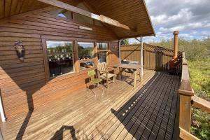 a wooden deck with a table and chairs on it at Vörðufell Country Cabin in Selfoss