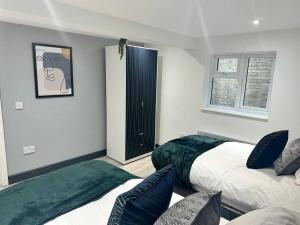 a bedroom with two beds and a cat picture on the wall at Abacus House in Huntingdon