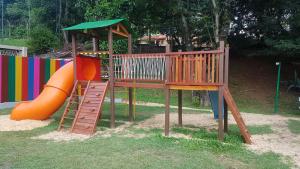 einen Spielplatz mit Rutsche und orangefarbener Rutsche in der Unterkunft Apartamento Familiar Com ou Sem Ar Condicionado in Porto Alegre