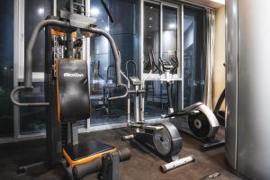 a gym with several treadmills and machines at Studio with city view in Bat Yam