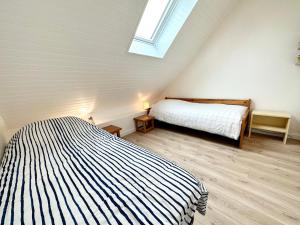 - une chambre avec un lit et une lucarne dans l'établissement Lovely ! T3 Duplex Hyper Cocooning, à Quiberon