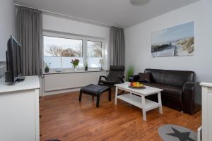 een woonkamer met een bank en een tafel bij Ferienwohnungen Haus Schau ins Land nah an der Nordsee in Emmelsbüll-Horsbüll