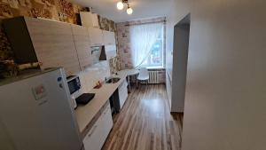 eine Küche mit weißen Geräten und Holzböden in der Unterkunft Sakņu 16/18 in Daugavpils