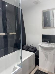 a white bathroom with a shower and a sink at Abacus House - TWO Bedroom Apartment in Huntingdon