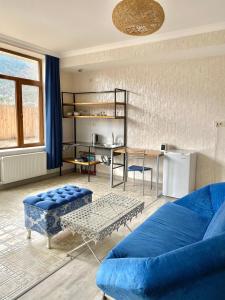 a living room with a blue couch and a table at Freeze Inn Mestia in Mestia