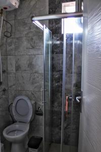 a bathroom with a toilet and a glass shower stall at My place studio in Ohrid