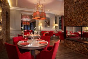 a dining room with red chairs and a table in a restaurant at Hôtel Mont-Blanc Chamonix in Chamonix