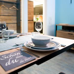 a table with plates and wine glasses on it at Apartment Magnolia in Karlstadt
