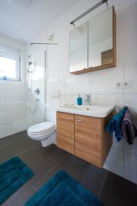 a bathroom with a sink and a toilet and two rugs at Apartment Magnolia in Karlstadt