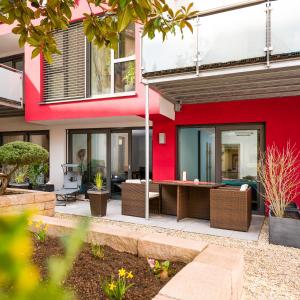 a house with a red wall and a patio at Apartment Magnolia in Karlstadt