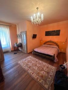 a bedroom with a bed and a chandelier at B&B VILLA ROSA in Anzino