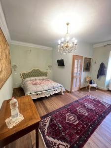 a bedroom with a bed and a table and a chandelier at B&B VILLA ROSA in Anzino