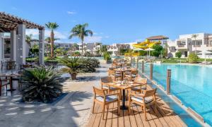 Iberotel Casa Del Mar Resort في الغردقة: فناء به طاولات وكراسي بجانب مسبح