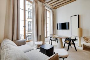 een woonkamer met een bank en een tafel bij Pick A Flat's Apartments in Louvre - Rue Saint Honoré in Parijs