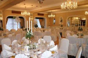 un salón de banquetes con mesas y sillas blancas y lámparas de araña en Revelstoke Hotel, en Bridlington