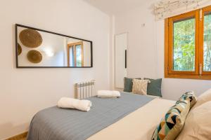 una camera da letto con un letto e uno specchio sul muro di Holytom Puerto Pollensa a Port de Pollença Altre 20 foto