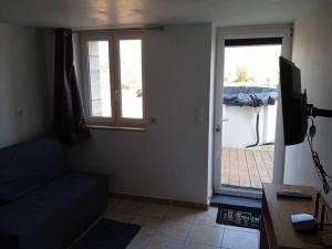 un soggiorno con un divano e una porta scorrevole in vetro di Petit logement avec entrée indépendante a Vellefrie