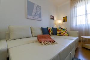 un sofá blanco sentado en una sala de estar en Apartment close to the Ria de Aveiro, São Jacinto en Aveiro
