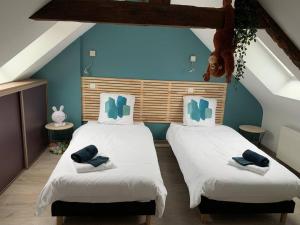 two beds in a room with blue walls at Duplex 6/8p centre Plouha in Plouha
