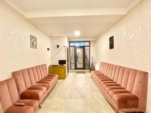 une salle d'attente avec des fauteuils en cuir brun et un bureau dans l'établissement Freeze Inn Mestia, à Mestia