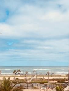 a view of a beach with palm trees and the ocean at Sea view apartments in Casablanca