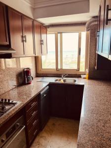 Sea view apartments في الدار البيضاء: مطبخ مع حوض ونافذة