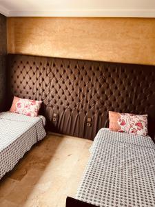 - une chambre avec 2 lits et une grande tête de lit dans l'établissement Sea view apartments, à Casablanca