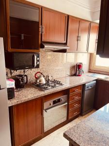 a kitchen with wooden cabinets and a stove top oven at Sea view apartments in Casablanca