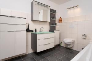 a white bathroom with a toilet and a sink at Ferienwohnungen Haus Schau ins Land nah an der Nordsee in Emmelsbüll-Horsbüll