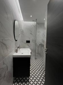 a bathroom with a sink and a shower at Penthouse & apartments by the Sea airport Airstay in Artemida