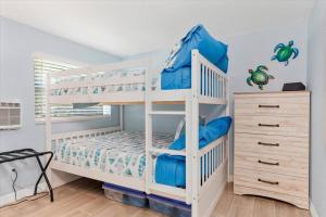 ein weißes Etagenbett mit blauen Kissen in einem Zimmer in der Unterkunft Waterfront home in Punta Gorda