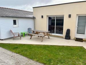 une terrasse avec une table de pique-nique en bois et un banc dans l'établissement L'Ostréa, maison avec jardin à 200m de la mer-wifi, à Saint-Côme-de-Fresné