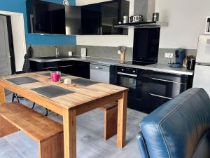 - une cuisine avec une table en bois dans l'établissement L'Ostréa, maison avec jardin à 200m de la mer-wifi, à Saint-Côme-de-Fresné