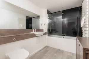 y baño con ducha, lavabo y bañera. en Luxury Apartment with Balcony, Free Parking en St Andrews