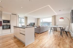 una cucina e un soggiorno con tavolo e divano di Luxury Apartment with Balcony, Free Parking a St Andrews