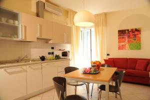 a kitchen and living room with a table and a red couch at Residence San Paolo in Lido di Savio