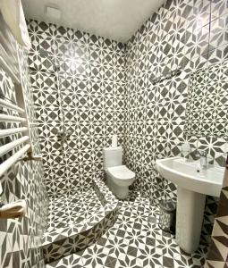 a bathroom with a black and white tiled wall at Freeze Inn Mestia in Mestia