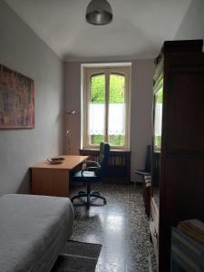 a bedroom with a bed and a desk and a window at Croisette in Turin