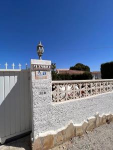 a stone pillar with a sign on it next to a fence at ¡Magnifica Villa Amalia! in Calpe