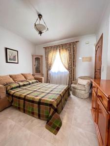 a bedroom with a bed and a chair and a window at ¡Magnifica Villa Amalia! in Calpe