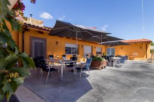 AlbergueMyway في أستورغا: فناء في الهواء الطلق مع طاولات وكراسي ومظلات