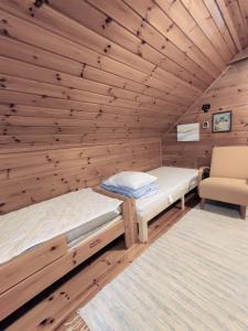 1 dormitorio con 2 camas en una cabaña de madera en Villa Haapala, en Rovaniemi