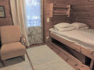 1 dormitorio con 1 cama, 1 silla y 1 ventana en Villa Haapala, en Rovaniemi